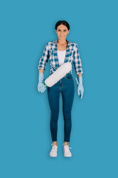 Reinigungskraft in Schutzhandschuhen mit Staubwedel isoliert auf blauem Hintergrund — Stockfoto