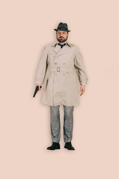 Vista superior del asesino masculino en sombrero con pistola aislada sobre fondo rosa - foto de stock