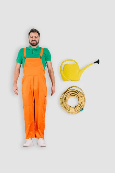 Top view of male gardener with watering can and hose isolated on white background — Stock Photo