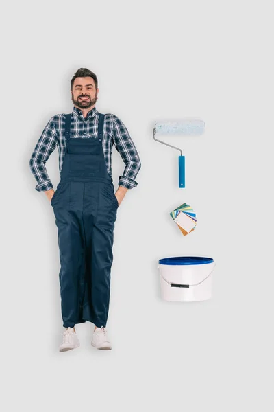 Top view of repairman with paint roller and bucket of paint isolated on white background — Stock Photo