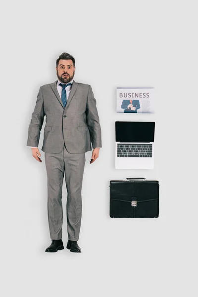 Vue du dessus de l'homme d'affaires avec journal, ordinateur portable et serviette isolé sur fond blanc — Photo de stock