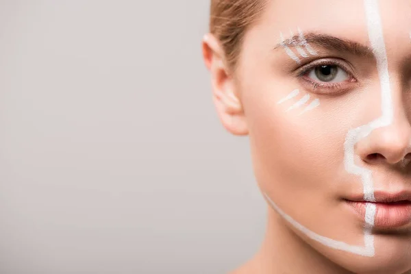 Image recadrée d'une jolie femme avec des lignes blanches sur le visage isolé sur le gris — Photo de stock