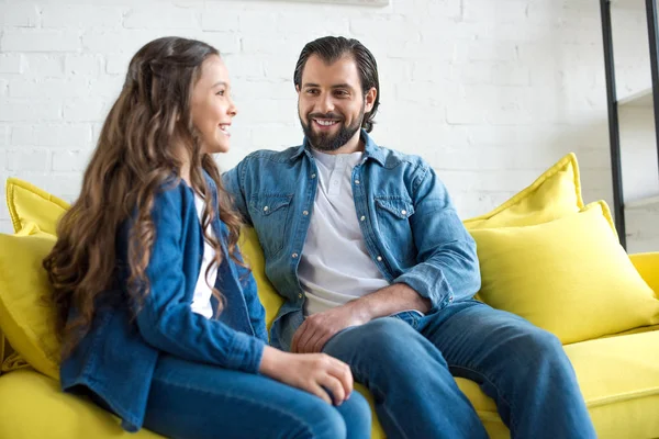 Glücklicher Vater und Tochter in Jeanskleidung sitzen zusammen auf der Couch — Stockfoto