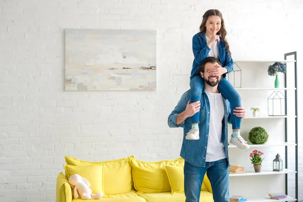 Happy father carrying smiling daughter on neck and having fun together at home — Stock Photo