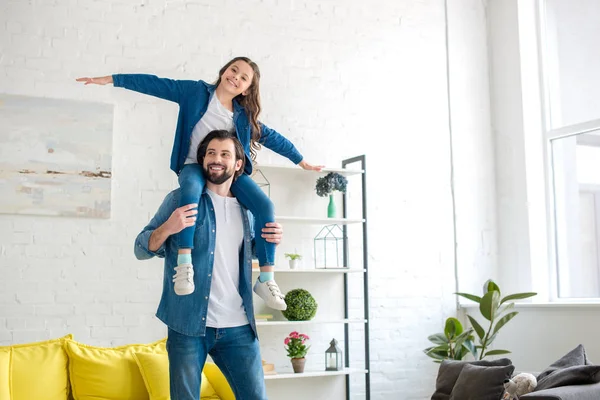 Feliz padre llevando linda hija en el cuello y divertirse juntos en casa - foto de stock