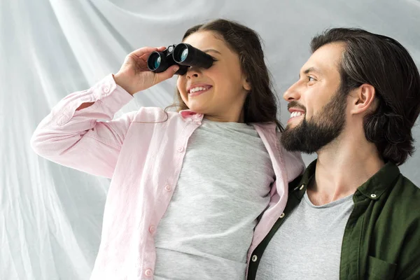 Happy father and daughter having fun together and playing with binoculars — Stock Photo