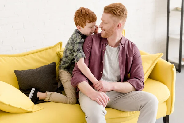 Glücklicher Vater und Sohn lächeln einander an, während sie Zeit miteinander zu Hause verbringen — Stockfoto