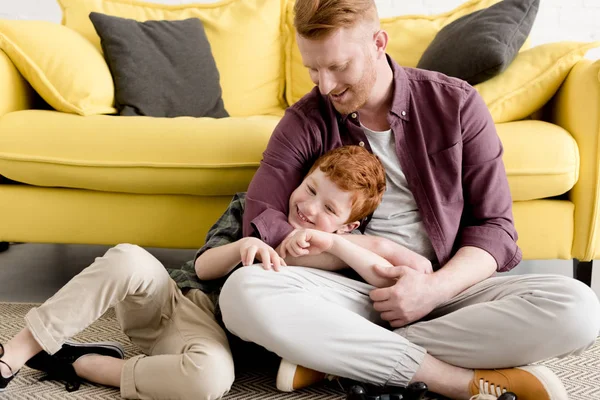 Feliz pelirroja padre e hijo pasando tiempo juntos en casa - foto de stock