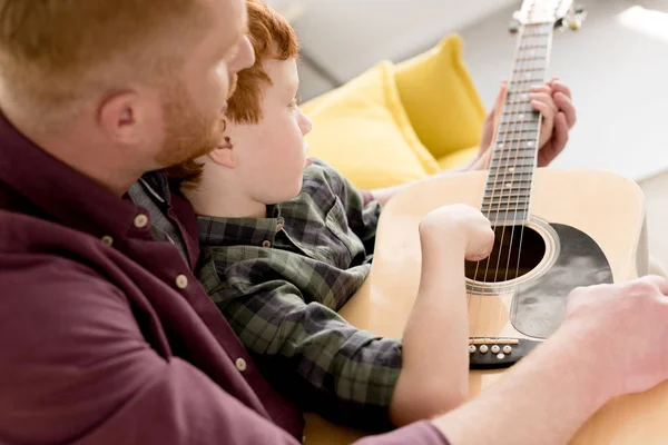 Кадр, где отец учит маленького сына играть на акустической гитаре — стоковое фото