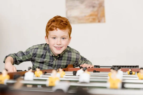 Cute smiling little boy playing table football — Stock Photo