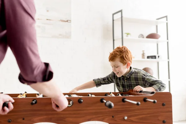 Selektiver Fokus von Vater und niedlich lächelndem Sohn beim gemeinsamen Tischkicker zu Hause — Stockfoto