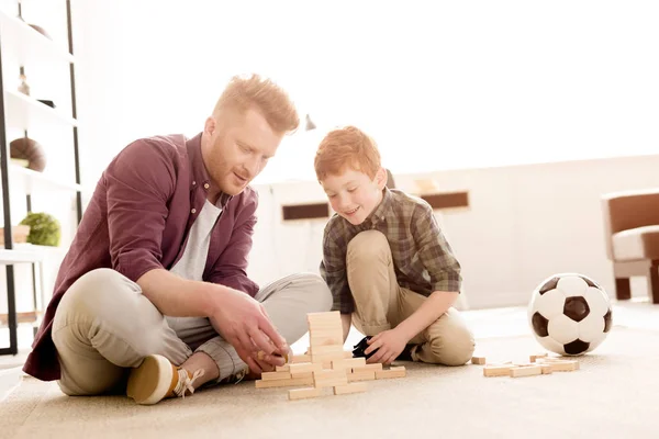Smiling father and son playing with wooden blocks at home — Stock Photo