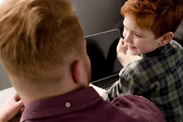 Tiro recortado de pai e filho usando laptop com tela em branco — Fotografia de Stock