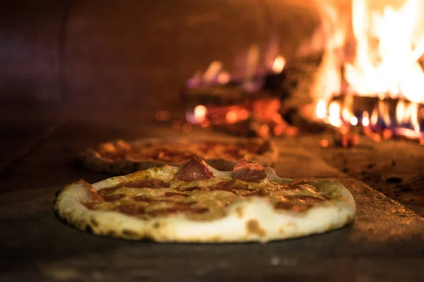 Close up view of italian pizza baking in brick oven in restaurant — Stock Photo