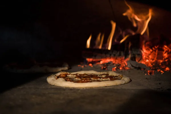 Vista de cerca de la pizza italiana hornear en horno de ladrillo en el restaurante - foto de stock