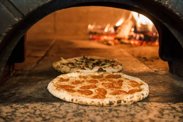 Close up view of italian pizza baking in brick oven in restaurant — Stock Photo