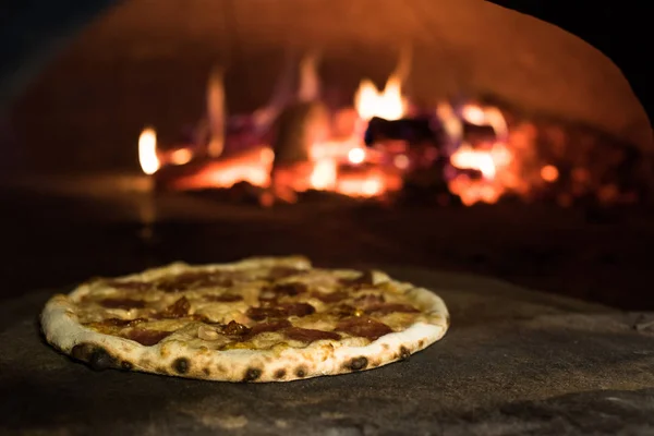 Close up view of italian pizza baking in brick oven in restaurant — Stock Photo