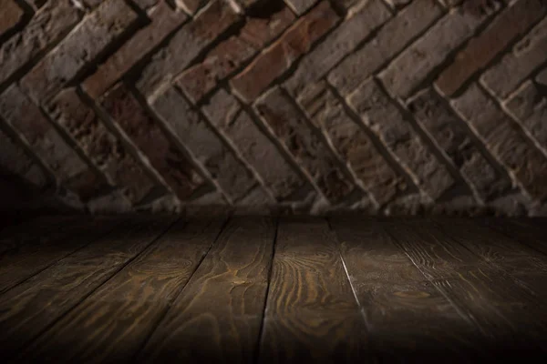 Close up view of wooden tabletop and brick wall background — Stock Photo