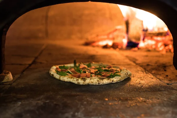 Close up view of italian pizza baking in brick oven in restaurant — Stock Photo