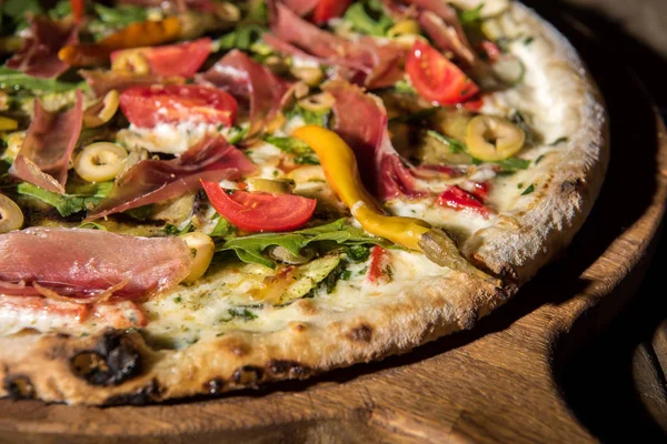 Vista de perto da pizza italiana recém-assada na placa de corte de madeira — Fotografia de Stock