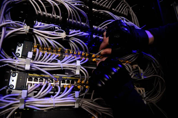 Cropped shot of hackrers hands in gloves and various cables — Stock Photo