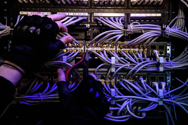 Cropped shot of hackrers hands in gloves and various cables — Stock Photo