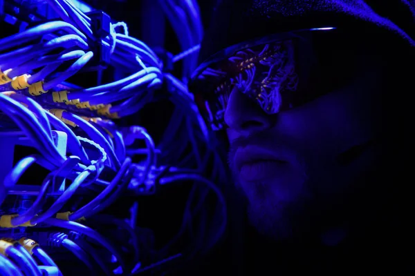 Visão lateral do hacker em óculos olhando para vários fios — Fotografia de Stock