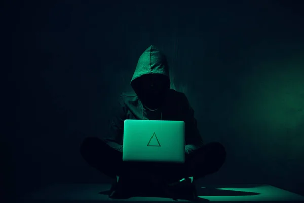Тонована картина силуету хакера в светрі з використанням ноутбука — стокове фото