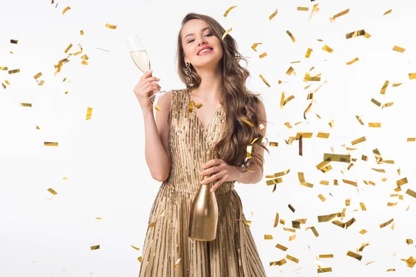 Sonriente atractiva mujer de pie con champán bajo la caída confeti aislado en blanco - foto de stock