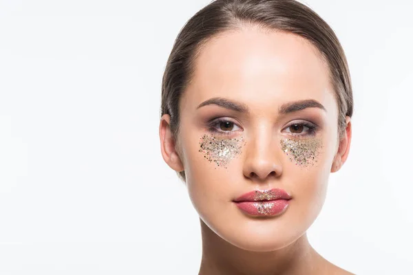 Portrait of attractive woman with glitter under eyes looking at camera isolated on white — Stock Photo