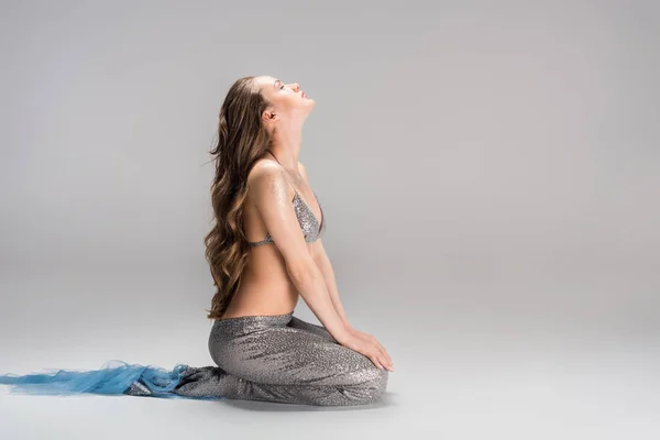 Вид збоку привабливої жінки з хвіст русалки сидить на підлозі — стокове фото