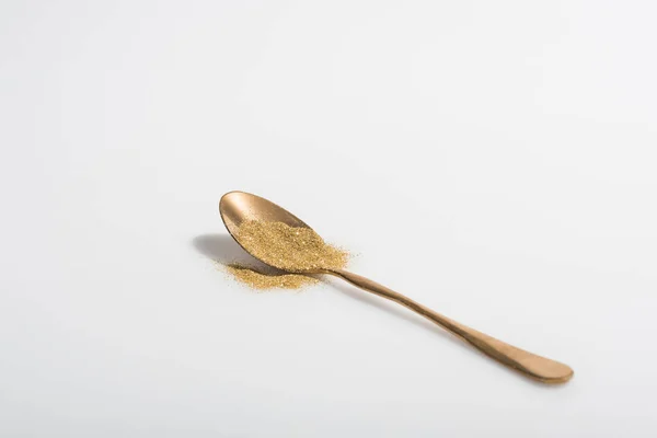 Goldener Löffel und heller Glanz auf weißer Oberfläche — Stockfoto