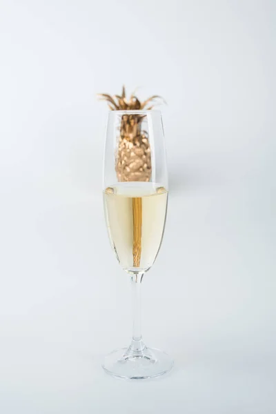 Copa transparente de champán y piña dorada aislada en blanco — Stock Photo
