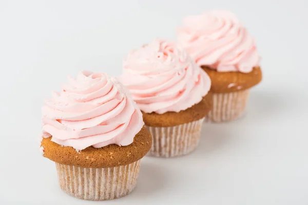 Délicieux cupcakes roses cuits sur blanc — Photo de stock