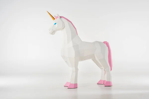 Unicorn toy with golden horn with pink hooves on white — Stock Photo