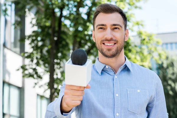 Journaliste souriant homme prenant entretien avec microphone — Photo de stock