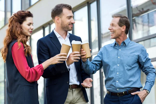 Fröhliches erfolgreiches Geschäftsteam, das mit Einwegbechern Kaffee klingelt — Stockfoto