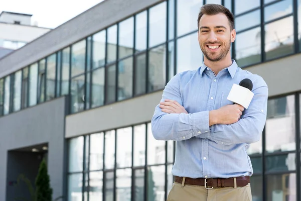 Alegre jornalista masculino posando com microfone fora — Fotografia de Stock