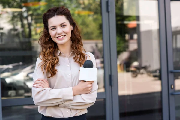 Attraktive Journalistin mit Mikrofon und Blick in die Kamera — Stockfoto