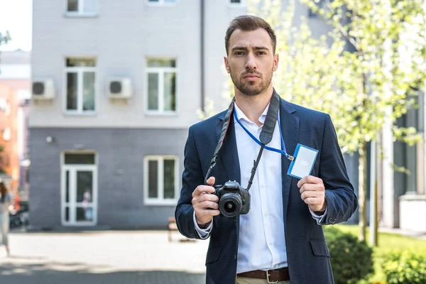 Fotoreporter che lavora con fotocamere digitali e pass stampa — Foto stock