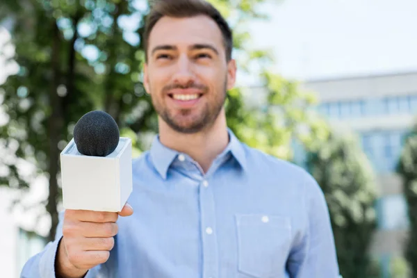 Anchorman sorridente che prende l'intervista con il microfono — Foto stock