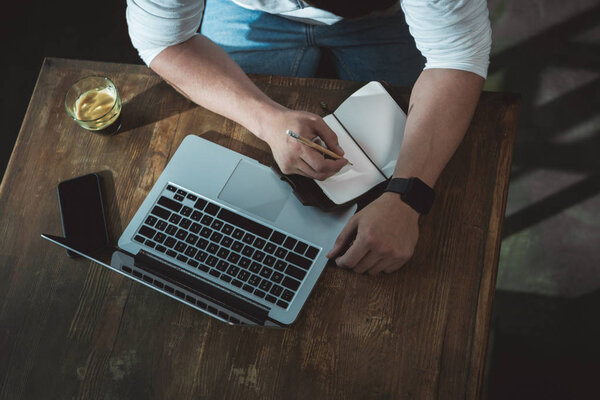 Man writing in notebook his plans