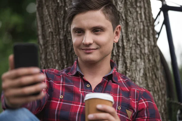 Man using smartphone at park — Stock Photo, Image