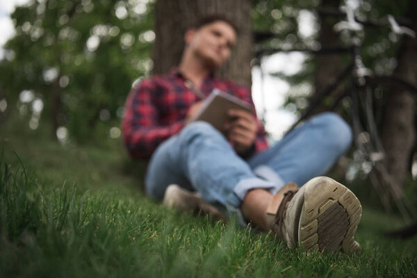 Young man taking notes in notebook