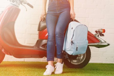 vintage motorla eğilerek sırt çantası ile atış kadının kırpılmış