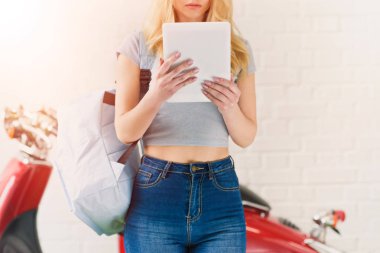 kırpılan çekim vintage scooter önünde tablet kullanan genç öğrenci kız