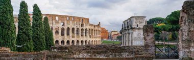 panoramic crop of ancient colosseum near historical buildings  clipart