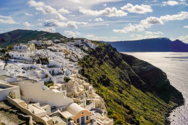 white houses near aegean sea against sky with clouds in greece  clipart