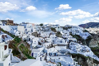 white houses on hill against sky with clouds in greece  clipart