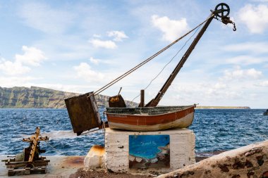 SANTORINI, GREECE - 10 NİSAN 2020: Yunan adasında deniz kenarında deniz kenarında deniz cehennemi harfleri bulunan yaşlı ve paslı bir tekne 